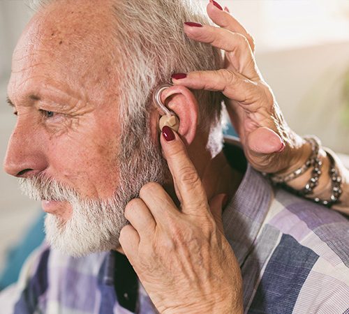 reconditioned hearing aids program: An elderly man getting fitted for a hearing aid.