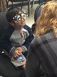 Young boy wearing vision goggles to test sight.