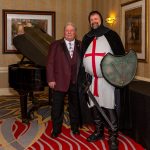 Knight and male in front of a piano in the Knights Quest gala.