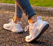 Woman's feet show walking while wearing sneakers